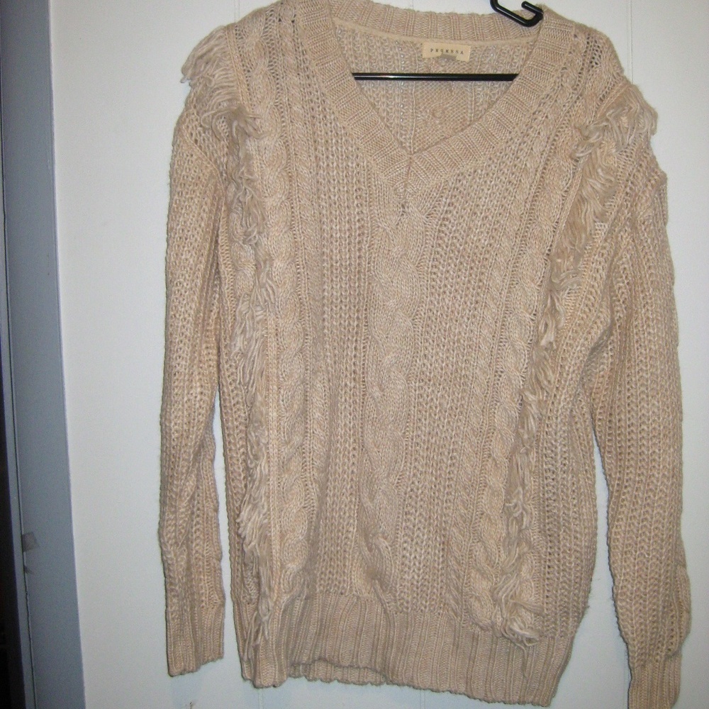 Cream Cable knit sweater with fringe.